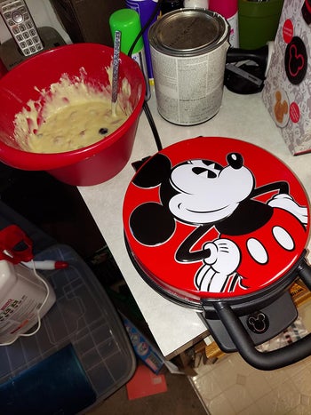 a red waffle maker with mickey on it