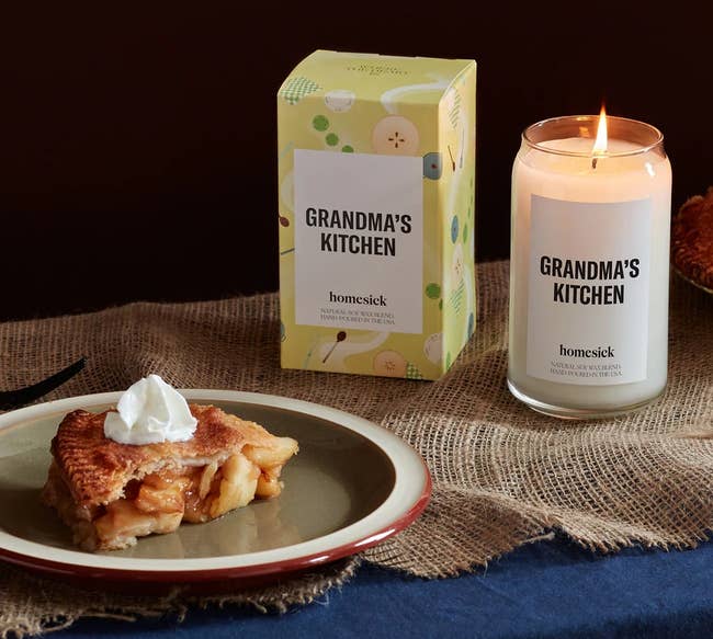 the grandma's kitchen candle and its box next to a slice of apple pie