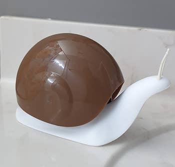 Snail-shaped soap dispenser on a bathroom counter, blending function with playful design for home decor enthusiasts