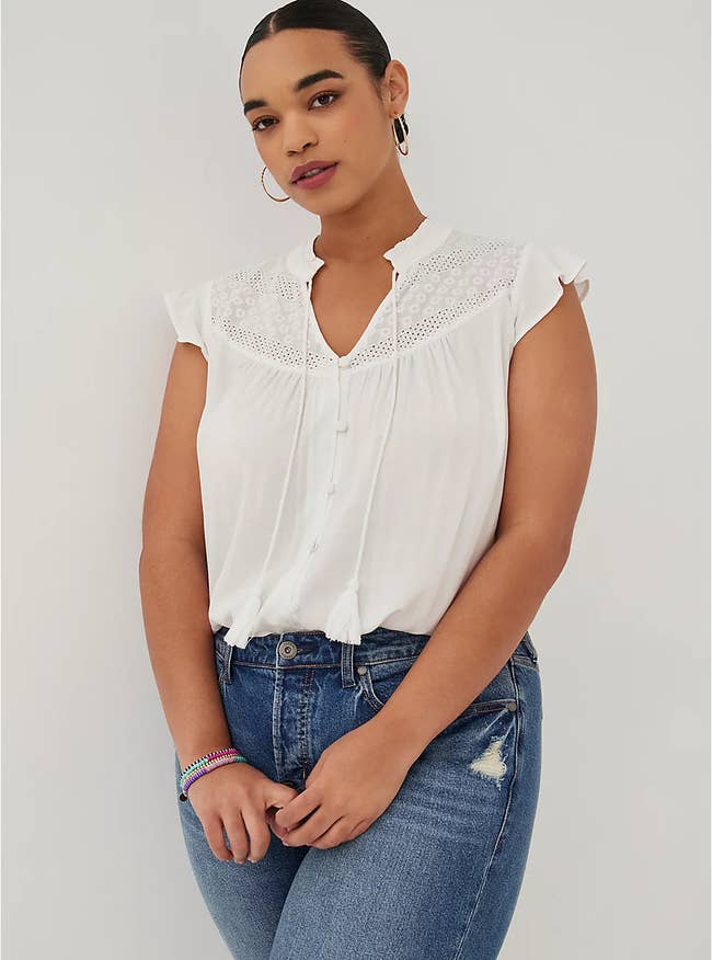 model wearing the white peasant blouse with blue jeans