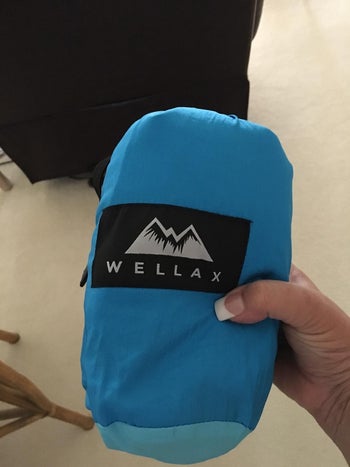 reviewer holding the rolled-up blanket, showing how small it can get