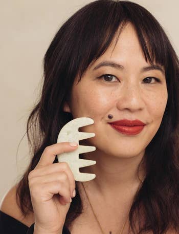 Founder holding the jade scalp stimulator next to their face