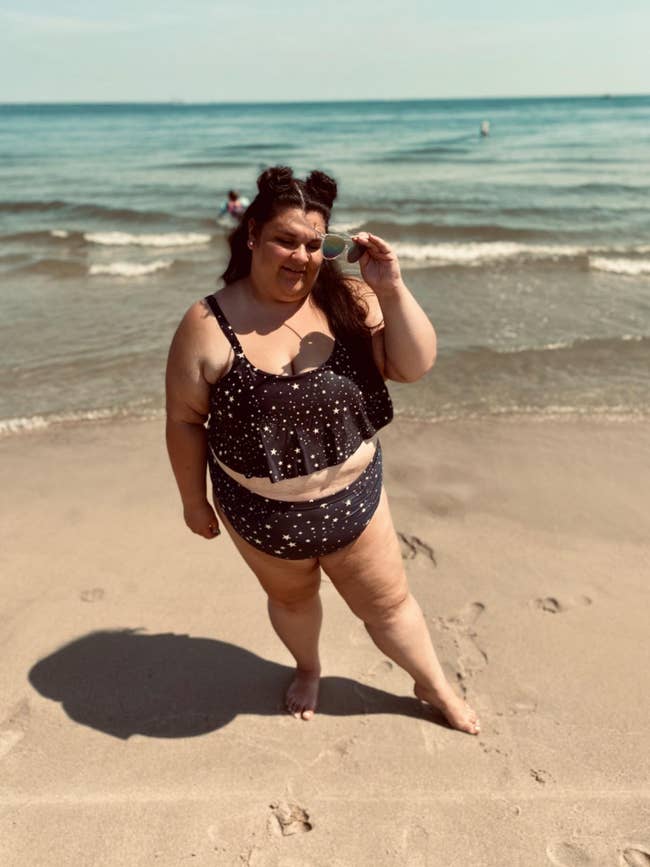 A reviewer in the black bikini with a star print, with high-waisted bottoms and a ruffly top