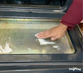 gif of someone applying the cleaner to a dirty oven door, then wiping away the stains