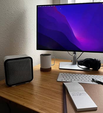 reviewer photo of the white space heater on a desk next to a computer