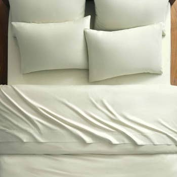 A neatly made furniture with respective pillows, showcasing smooth, crisp bedding, perfect for a clean, minimalist chamber style