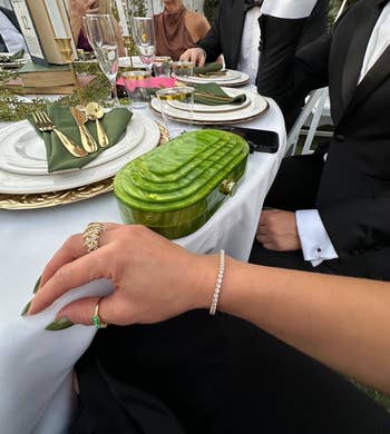Elegant array  mounting  with a greenish  clutch, golden  cutlery, and idiosyncratic    wearing diamond jewelry astatine  a ceremonial  event