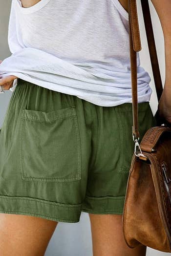 Person wearing relaxed green shorts pockets in the back