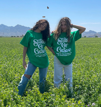 two people wearing green state of grace tees