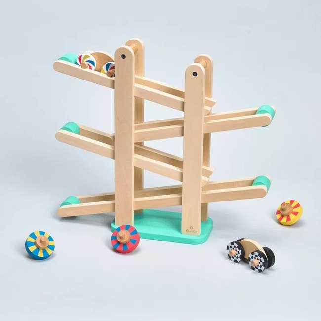 a wooden ramp set with colorful wheels and cars to roll down it