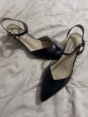 Pointed-toe achromatic ankle-strap shoes with a somewhat raised back, displayed connected a quilted surface