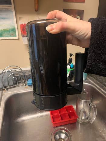 reviewer holding full pitcher of coffee upside down showing no leaks