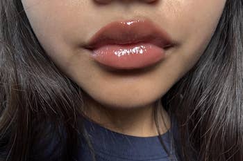 Close-up of a person's lips with glossy lipstick, showcasing a quality product
