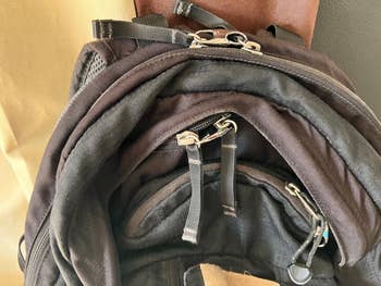 Close-up of a backpack with multiple zippers and compartments, showcasing its storage features for an article about shopping for bags