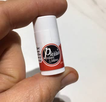 person holding tube of lip balm