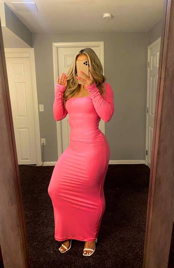 reviewer posing in bright pink dress