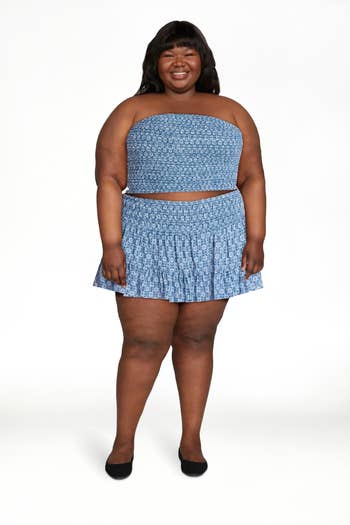 Person in a patterned tube top and skirt set, smiling. Ideal for a summer fashion article