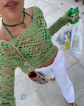 a model wearing the crocheted shirt over a bikini 