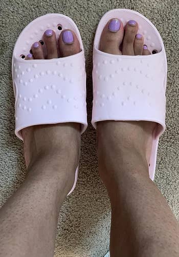 reviewer wearing the pink shower sandals