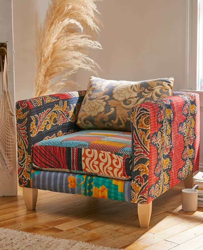Patterned upholstered armchair with a mix of floral and geometric designs in a bright room