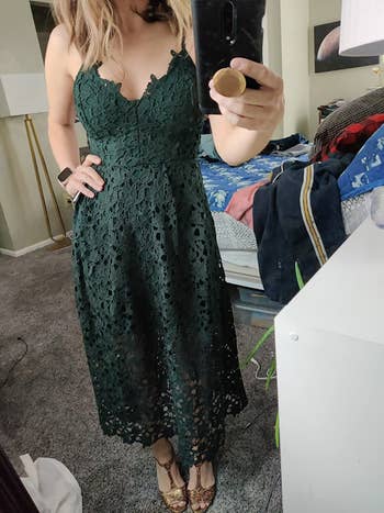 reviewer photo of them wearing a dark green lacy midi dress