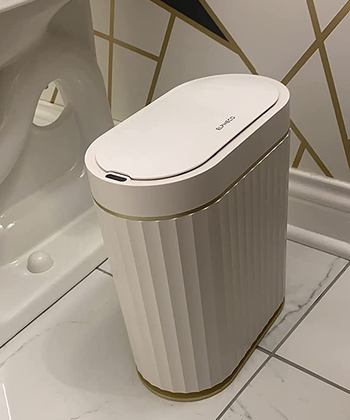 reviewer close-up of the white and gold garbage can