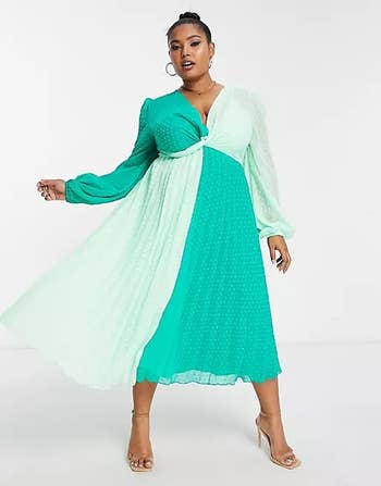model in long sleeve swiss dot pleated dress with twist at the bust and mint and teal color block