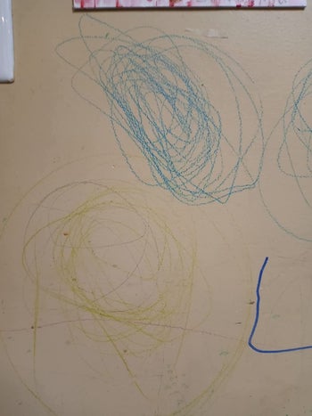 green and blue crayon marks on a white wall