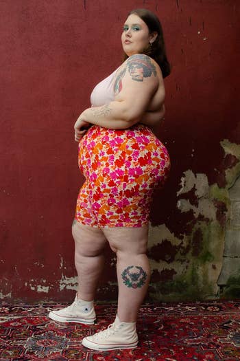side view of a plus-size model wearing the pink and orange floral bike shorts