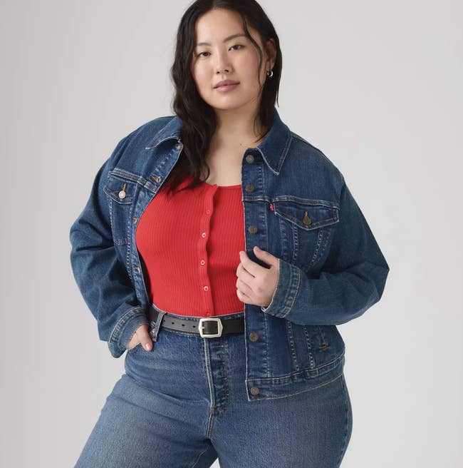 Person wearing a denim overgarment   and jeans implicit    a ribbed apical  with beforehand   buttons, posing confidently