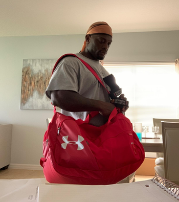 reviewer holding red Under Armour gym bag