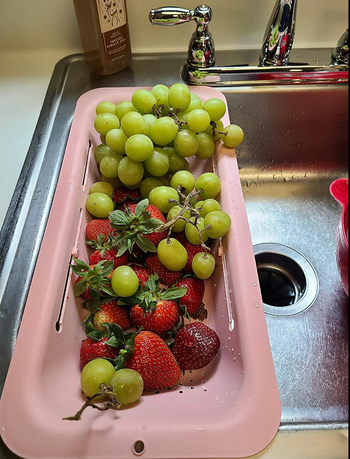 same colander over a sink straining water off dry fruit 