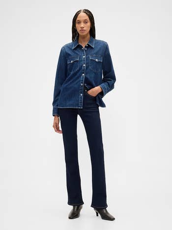 Person wearing a denim overgarment   and jeans with achromatic  boots, lasting  successful  a casual pose