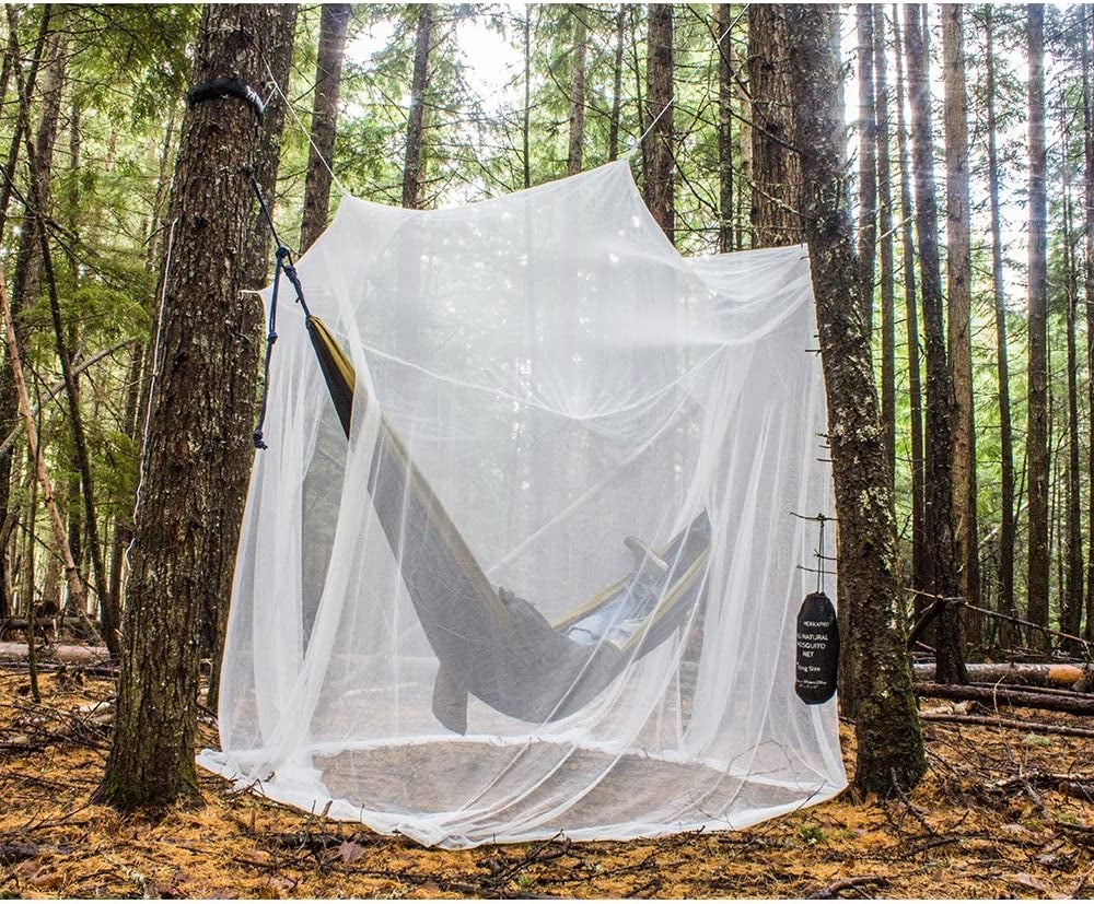 the product shot of the mosquito net over a hammock in the forest
