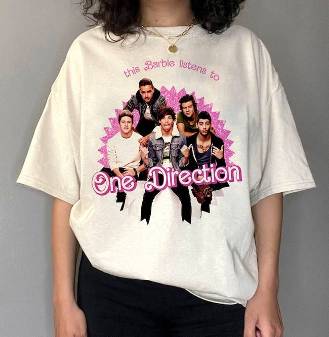 model wearing an oversized white T-shirt with a picture of One Direction on it and text that says 