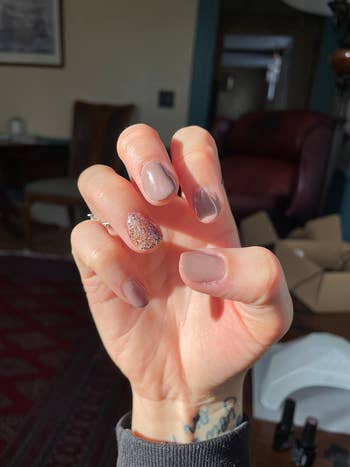 reviewer photo of their gel manicure with sparkles on one finger