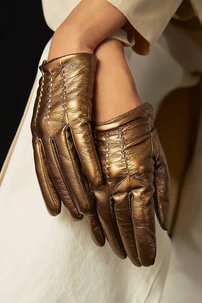 model wearing gold faux leather gloves that end right at the wrist