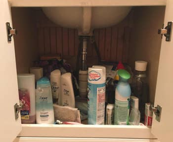 reviewer's pic of under bathroom sink with jumble of cleaning products