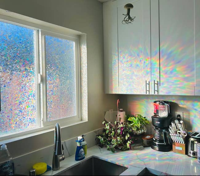 Rainbow light reflecting from a prismatic window onto a kitchen cabinet 