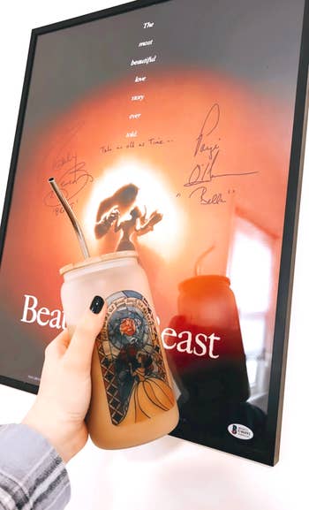 buzzfeed editor holding up a frosted glass can with a beauty and the beast stain glass design on it