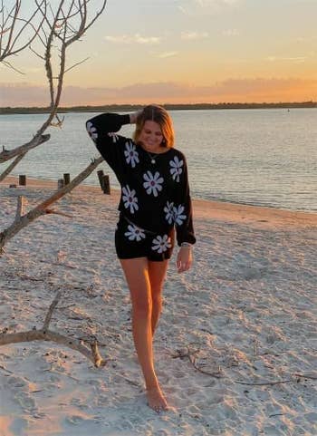 a model in a black two piece set with white daisies on it
