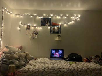 Cozy chamber  country   with drawstring  lights connected  the wall, laptop connected  furniture  showing a program, stuffed animals, and snacks