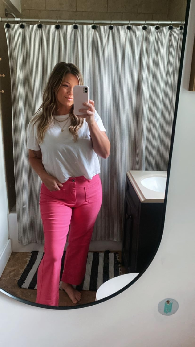 A idiosyncratic   successful  a achromatic  apical  and pinkish  pants takes a reflector  selfie successful  a bathroom, showcasing a casual buying  outfit