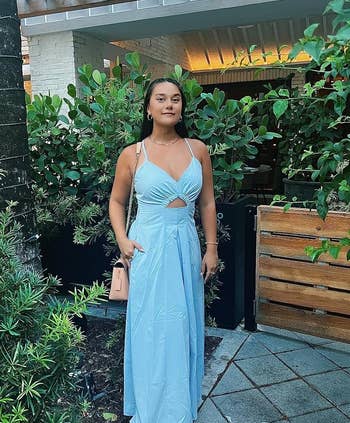 reviewer posing in a light blue cutout dress with spaghetti straps