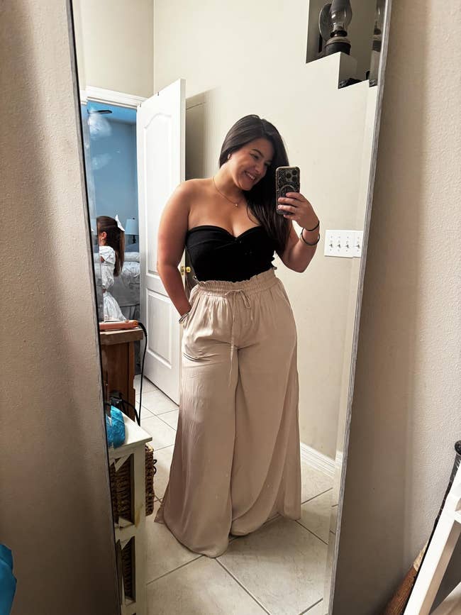 Person successful  a reflector  selfie wearing a strapless achromatic  apical  and beige wide-leg pants, suitable for buying  oregon  casual outings
