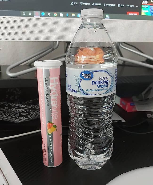 a pink tube of strawberry lemonade tablets next to a water bottle 