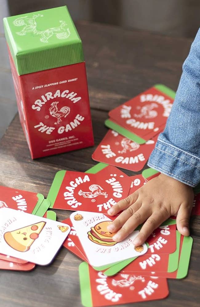 A sriracha-themed game box with the cards laid out on a table 
