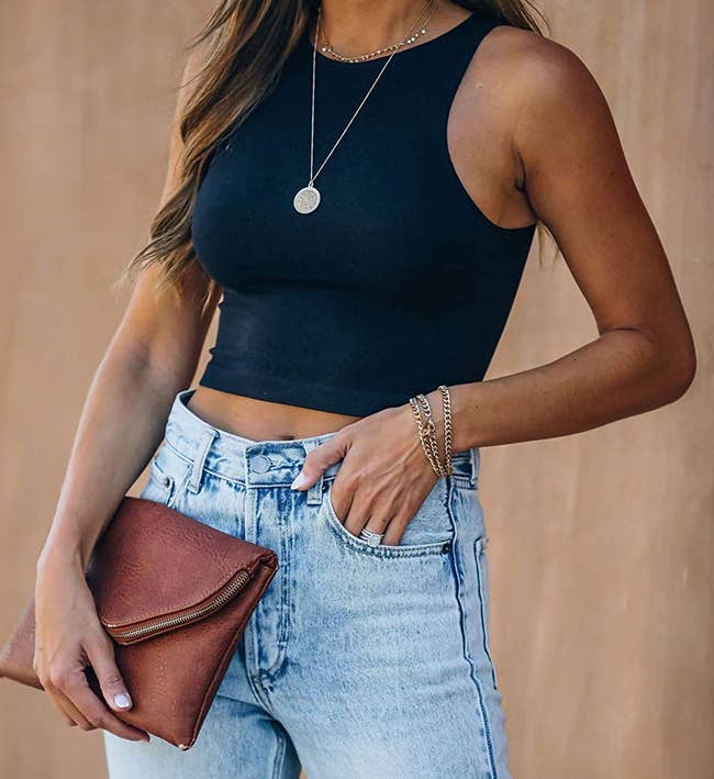 a model wearing the racerback crop top in black with jeans 