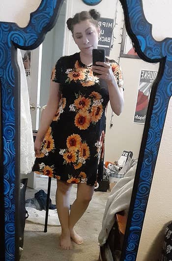 reviewer wears sunflower-print t-shirt dress while taking mirror selfie