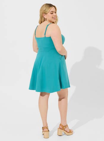 Model in a teal sleeveless A-line dress 